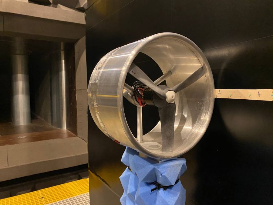 Close-up of a ducted propeller mounted on a test stand inside an anechoic chamber, surrounded by grey acoustic foam panels, used for controlled aerodynamic noise experiments.