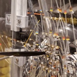 Instrumented model aircraft in a test rig, surrounded by sensors, tubing, and acoustic measurement equipment.