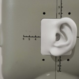 Close-up of an artificial ear on a measurement head used for acoustic and hearing research.
